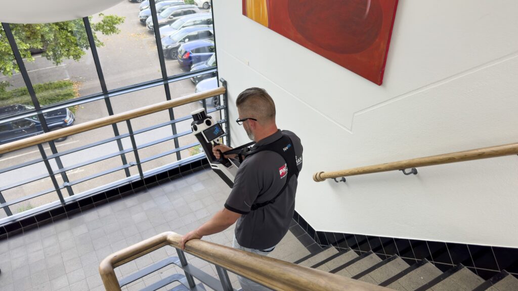 3D laserscan specialist met de NavVis MLX 3D laserscanner lopen aan het scannen in een trappenhuis.